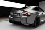 bmw g87 m2 carbon fibre rear spoiler view in a showroom