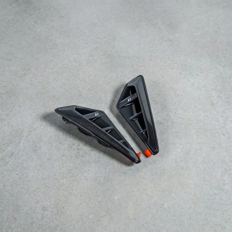 BMW X5M F95 carbon fibre side fenders M-Performance style – front angle view with gloss carbon finish and aerodynamic vents