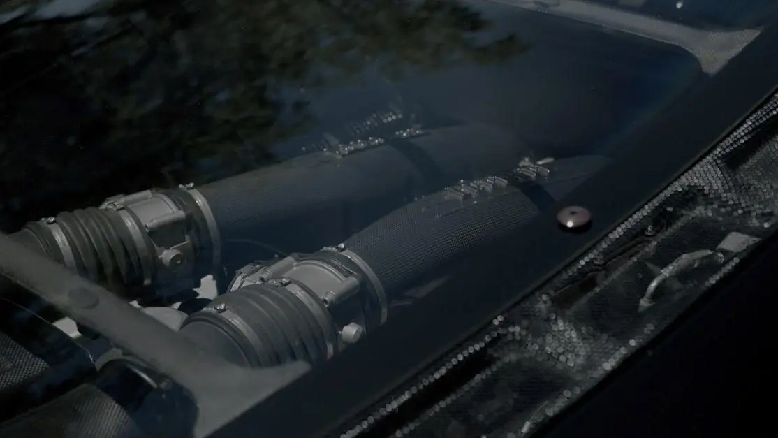 Carbon fiber engine bay with focus on cold air intake warranty.