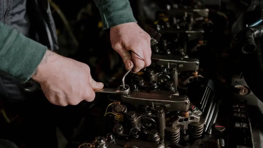 Mechanic installing an intercooler with hand tools, demonstrating precision and skill.