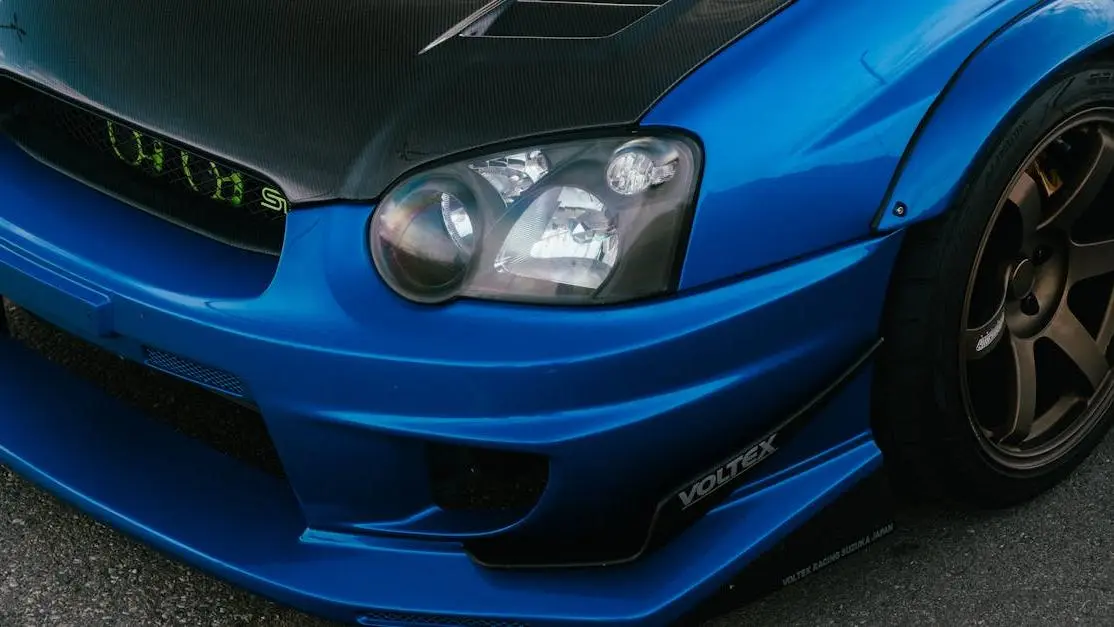 Modified blue Subaru STI with bronze wheels and carbon fiber hood showcasing how to install a front lip spoiler.