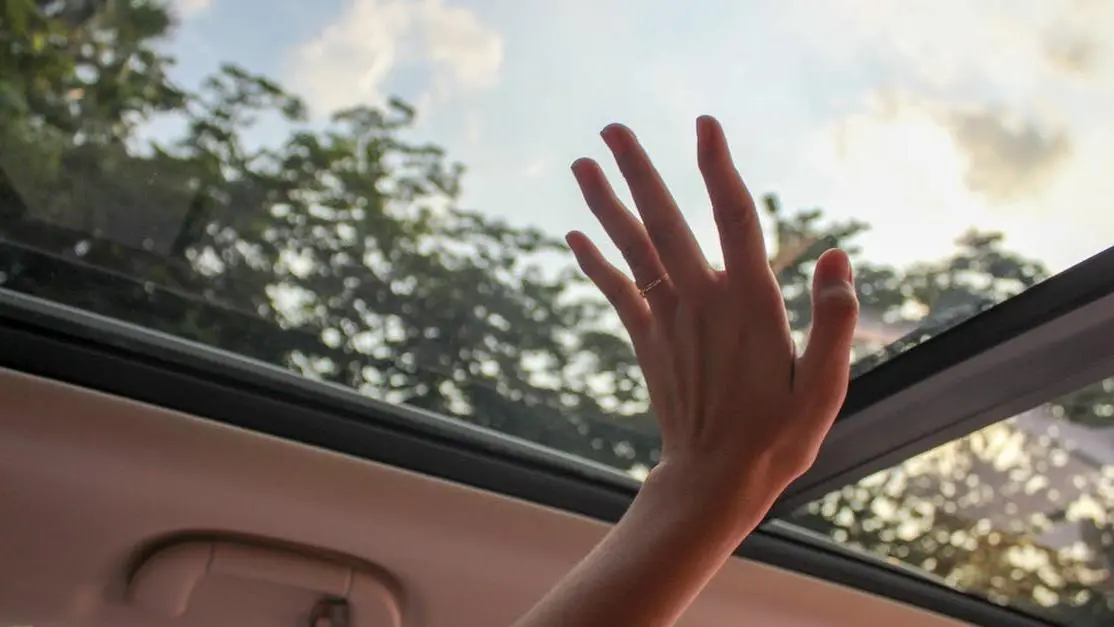 Installing sunroof wind deflector on sunny day.