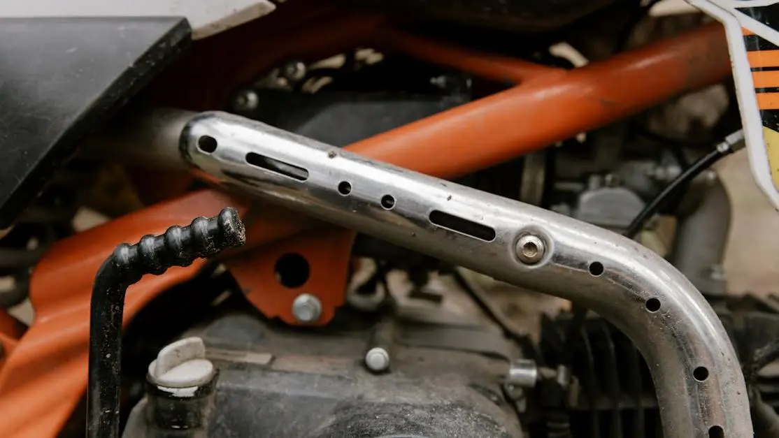 Dirt bike exhaust comparison: titanium vs stainless steel, highlighting metallic differences and design.