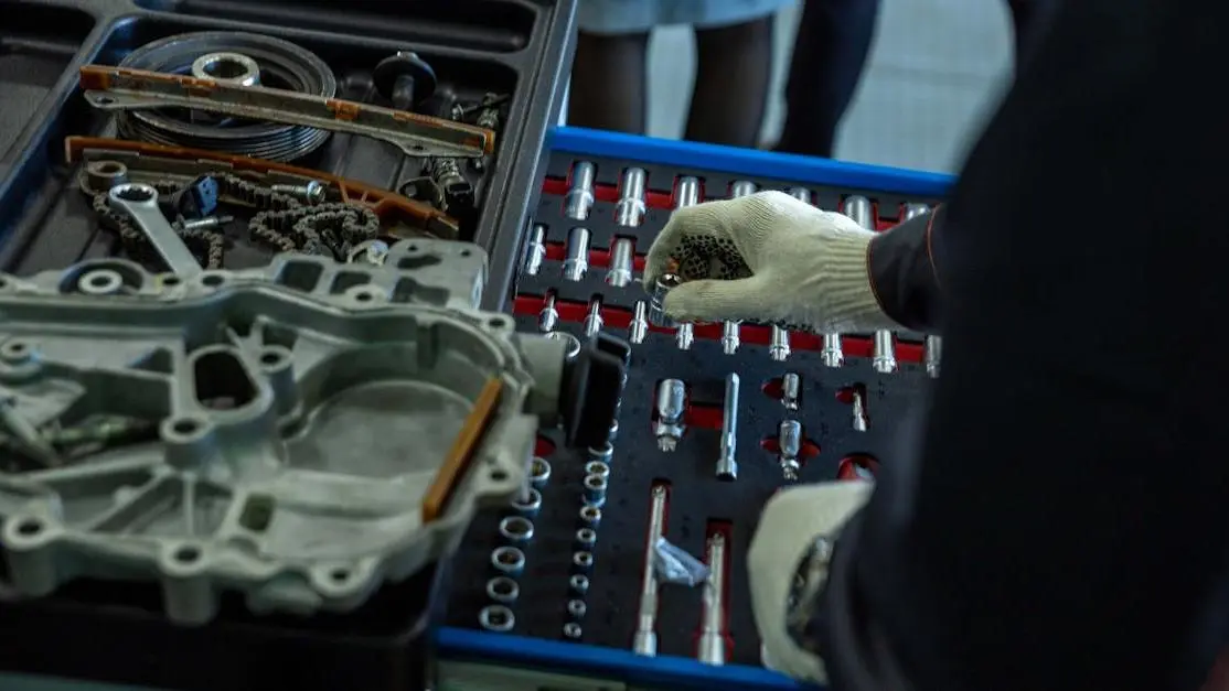 Mechanic organizing auto market parts and tools in workshop