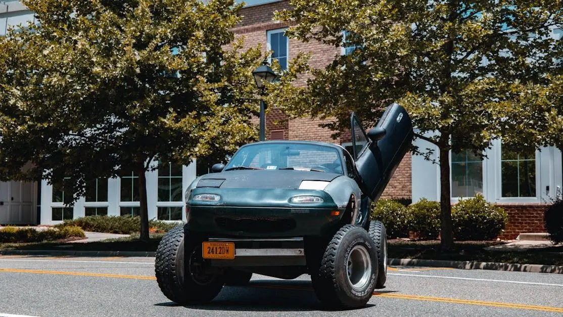 Off-road customized body kit for Mazda Miata parked on a tree-lined street
