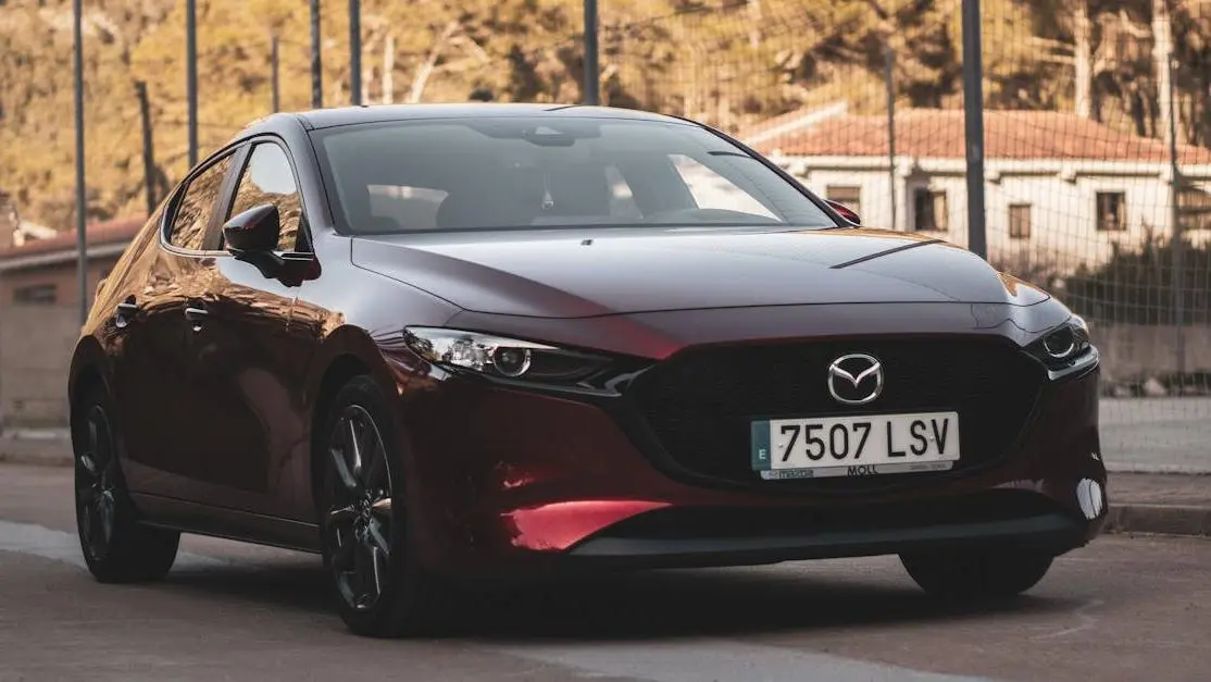 Red Mazda RX-8 on a sunny urban street, showcasing sleek styling and body kits for Mazda RX 8