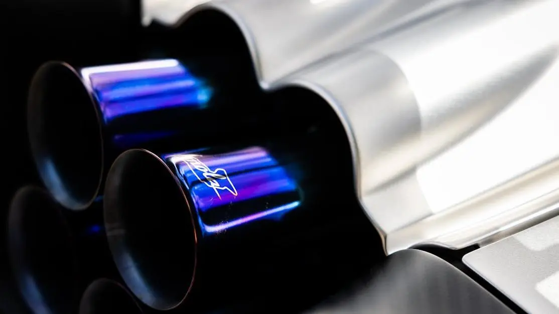 Shiny car exhaust close-up showcasing reflective metal, highlighting performance and tuning