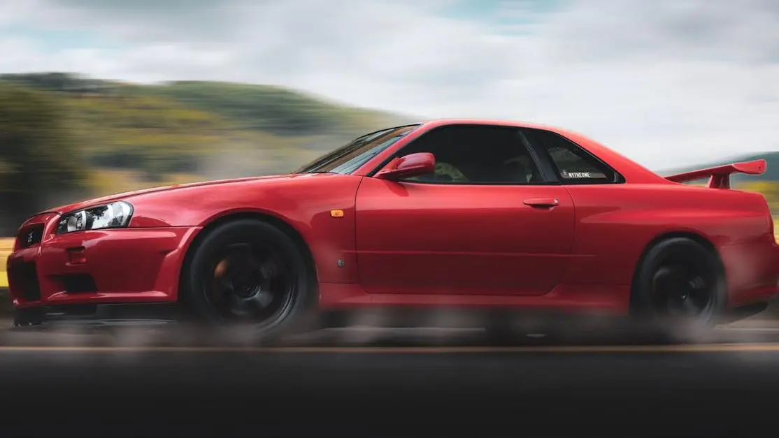 Red sports car on scenic highway, sleek design highlighting performance parts cars