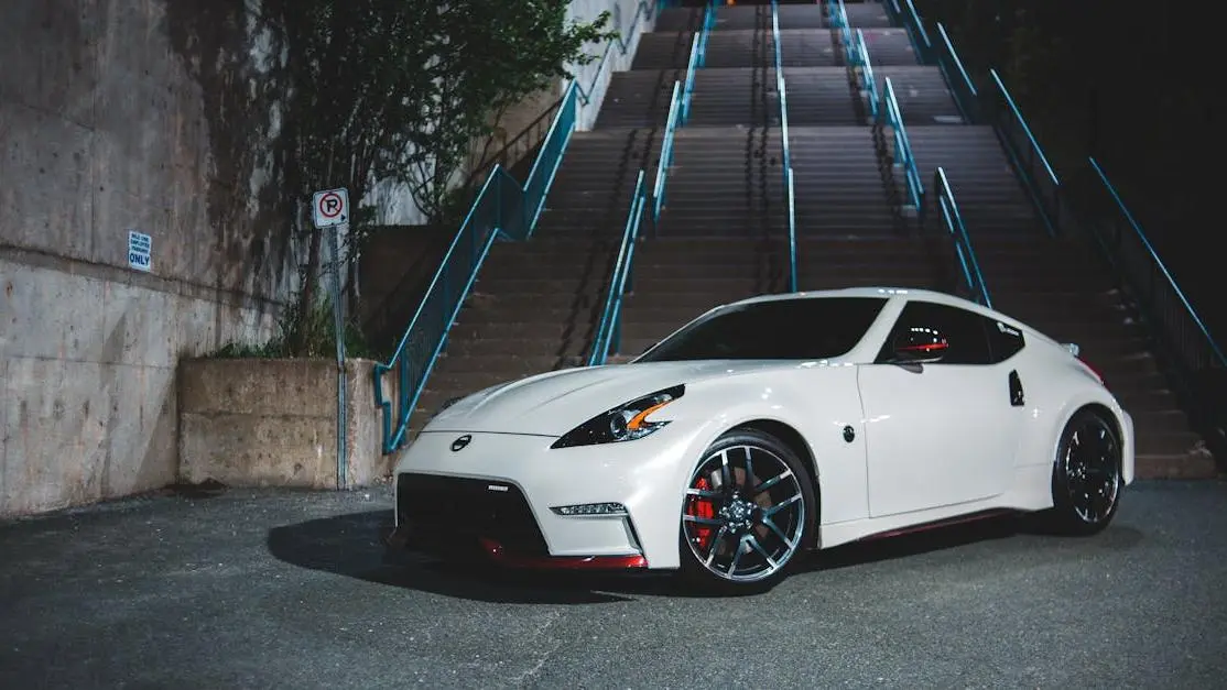 White RX8 Mazda body kit on a parked sports car at night near a stairway