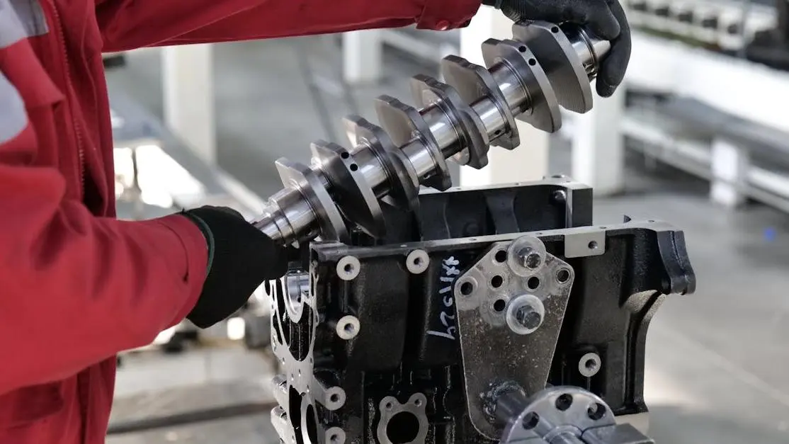 Mechanic installing a crankshaft in an engine block, showcasing skills in the aftermarket industry