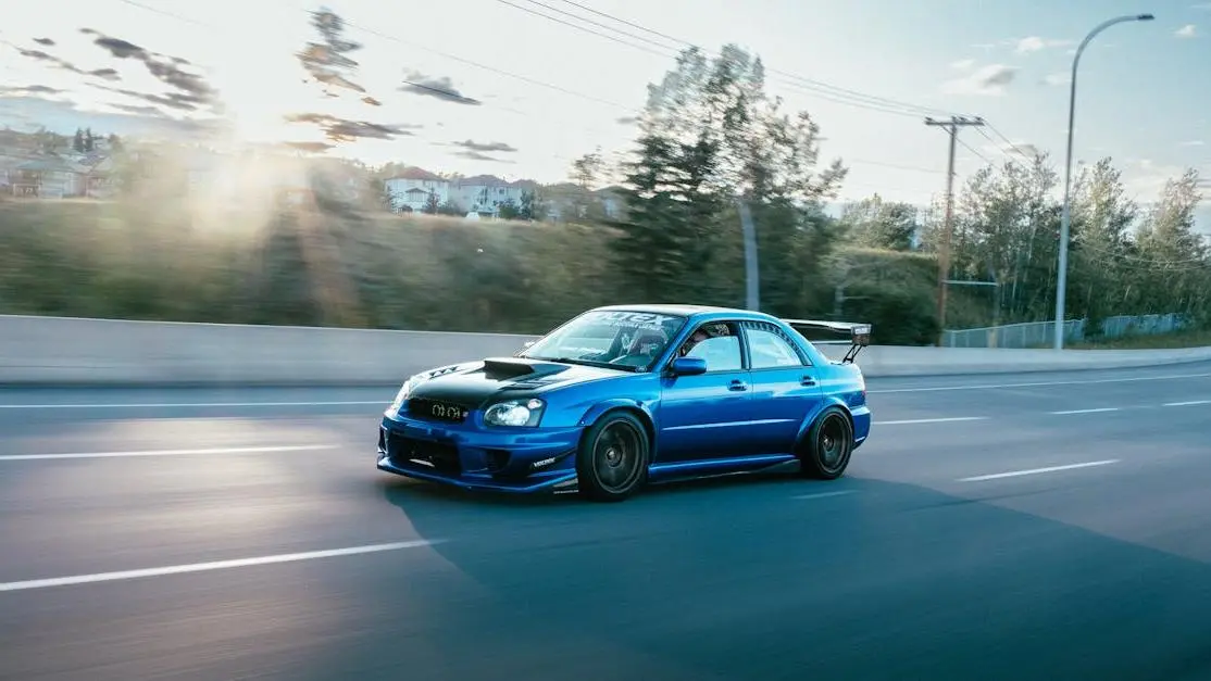 Blue modified Subaru WRX STI speeding through city, showcasing performance in the auto aftermarket