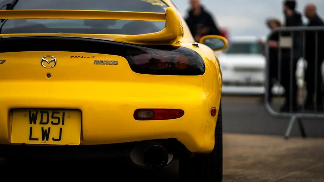Yellow Mazda RX-7 at Japfest 2025 highlighting sleek rear, showcasing body kit for Mazda RX7