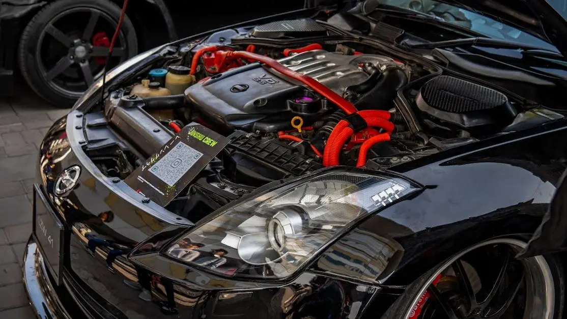 Close-up of high-performance car engine at showcase event, highlighting ECU MoTeC tuning components