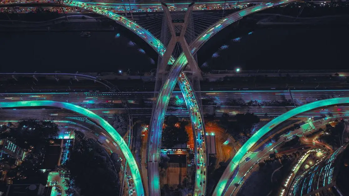 Night aerial of illuminated highways and cable-stayed bridge, symbolizing SQL query optimization efficiency