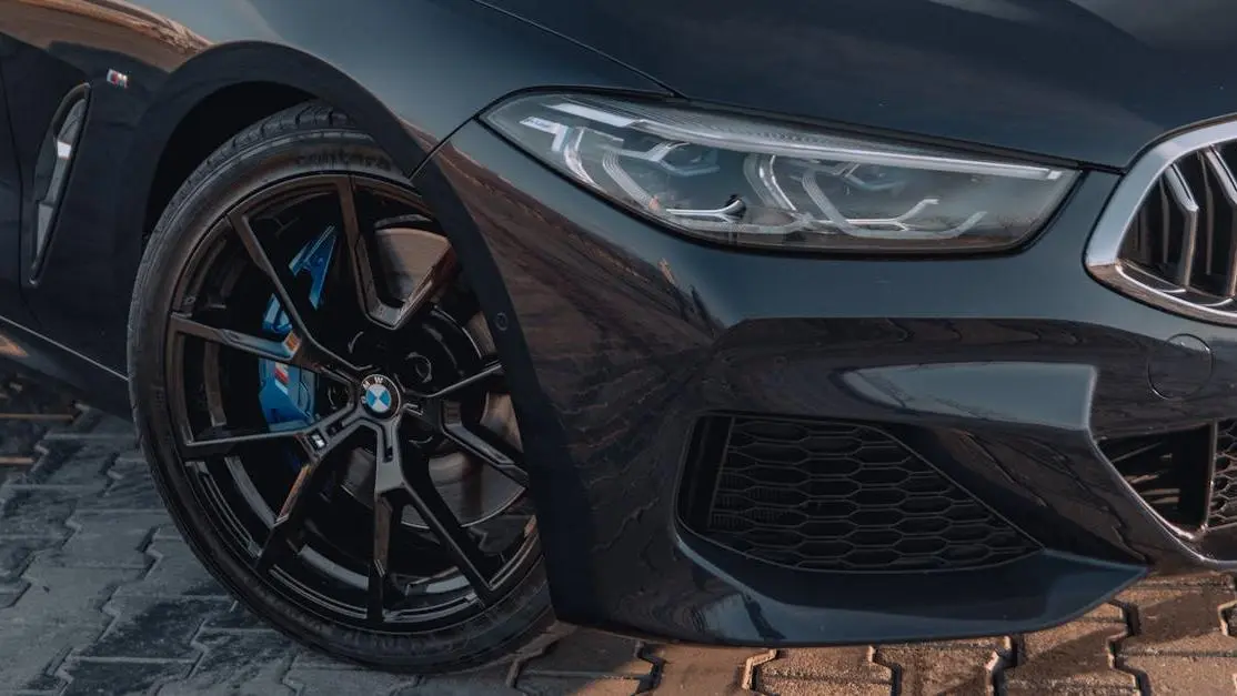 Advan GT wheel close-up on black car, glossy finish on paved surface
