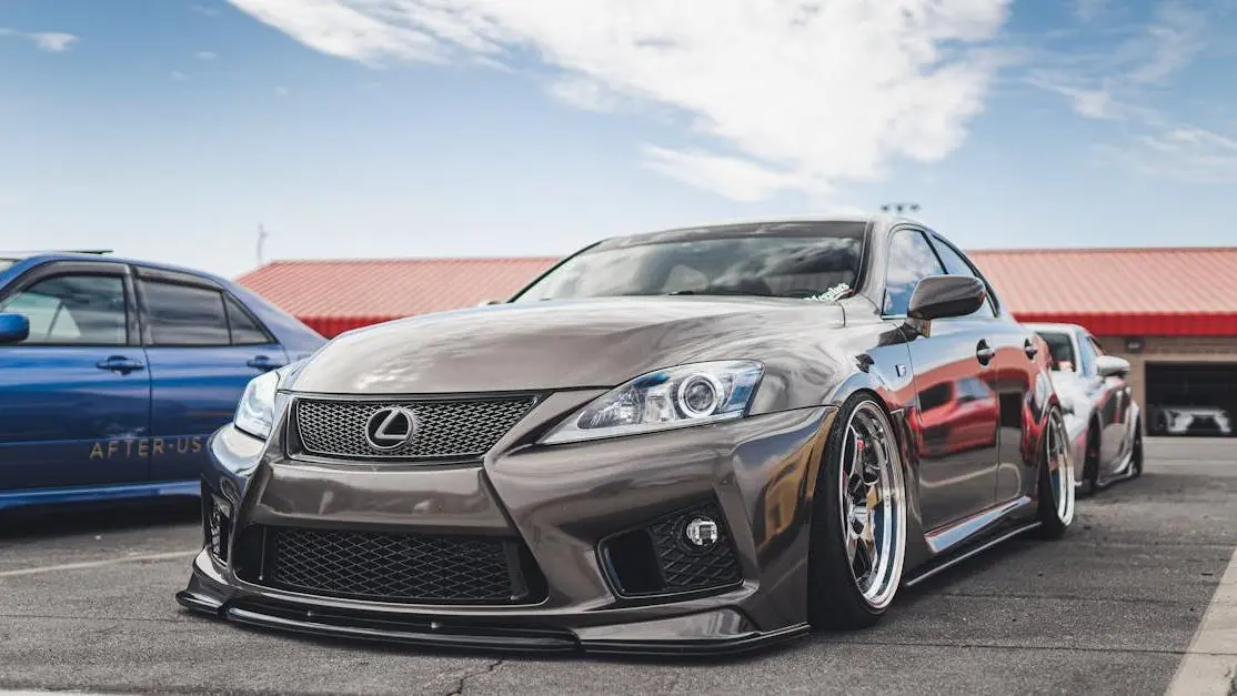 Sleek Lexus with alloy rims and sporty body kit showcasing aftermarket automotive body parts outdoors