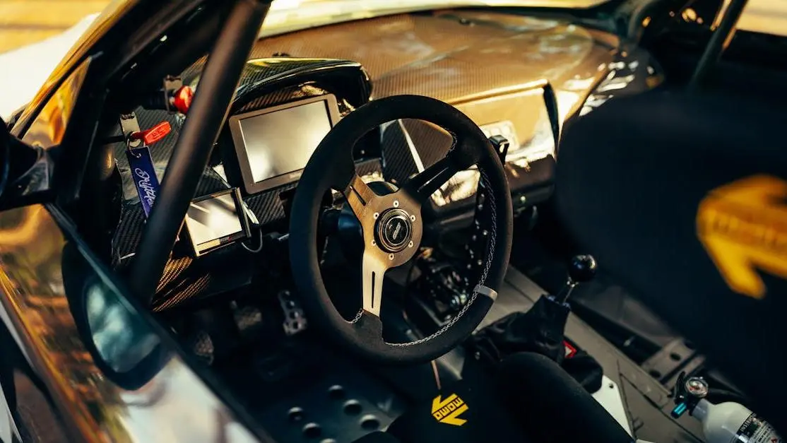Race car steering wheel close-up with dashboard controls in a racing cockpit cover photo